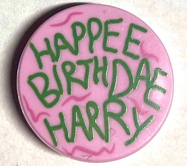 14769pb459 | Tile, Round 2 x 2 with Bottom Stud Holder with Green 'HAPPEE BIRTHDAE HARRY', Dark Pink Swirls Pattern | LEGOPART